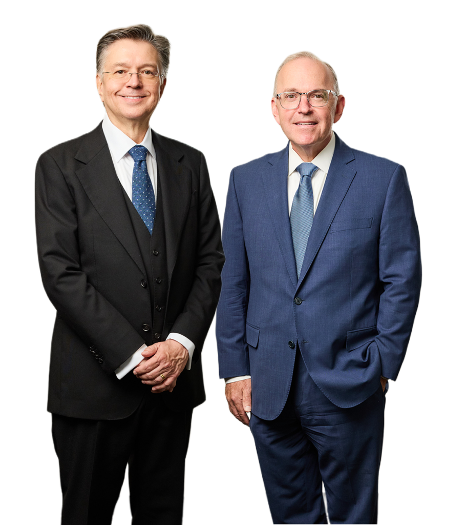 Two men in suits standing together, smiling.